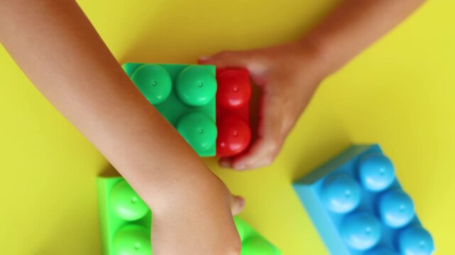 Delight in the sight of a child's hands expertly piecing together a vibrant construction kit. This video highlights the importance of hands-on play in developing critical skills and imagination.