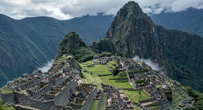 Aerial view of Machu Picchu ancient ruins nestled in lush Andean mountains with misty peaks