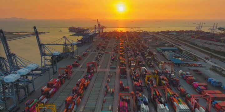 Large industrial sea harbor terminal featuring container cargo ships under golden sunset sky showing global logistics shipping operations with heavy cranes lifting metal boxes for international