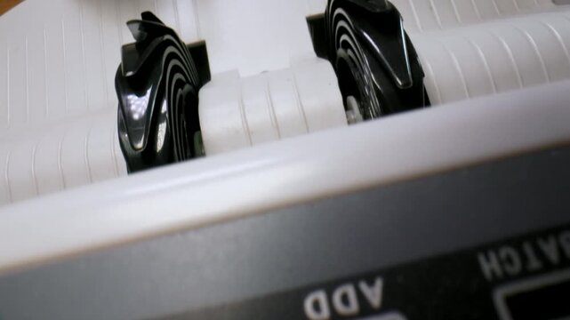 Extreme macro shot of 100 Euro banknotes in a cash counting machine