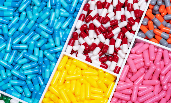 Multi-colored capsule pills in plastic drug tray. Pharmacology. Pharmaceutical industry. Drug of choice. Drug and supplement interactions. Prescription drug. Full frame capsule pills. Pharmacy banner.