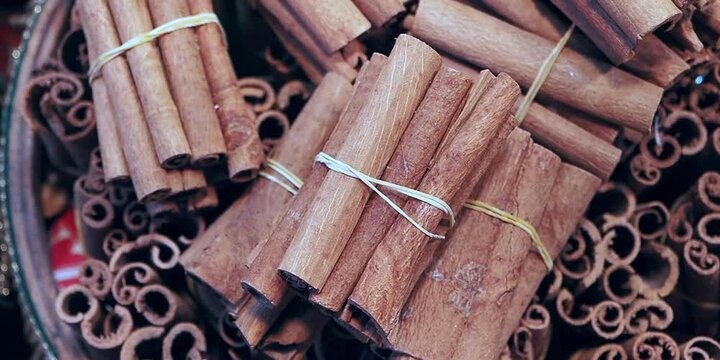 Aromatic cinnamon sticks bundled together with small string on a tray for culinary use in kitchens preparing festive desserts and warm seasonal beverages during autumn holidays in the rustic home