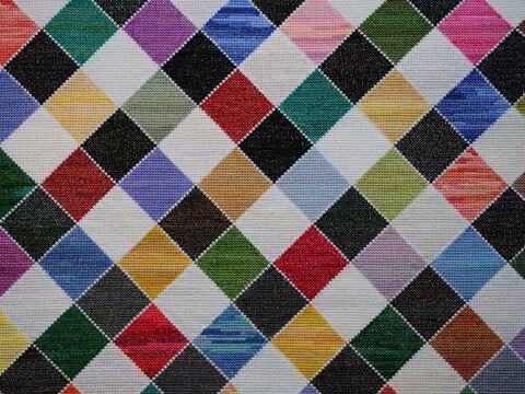 Colourful checkered pattern hand embroidered in cross-stitch background