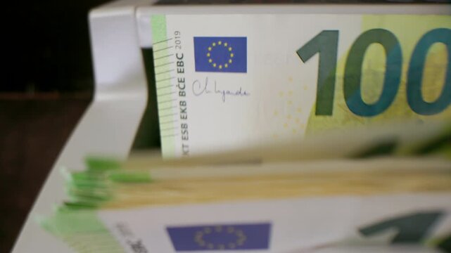 Extreme macro shot of 100 Euro banknotes in a rapid cash counting machine