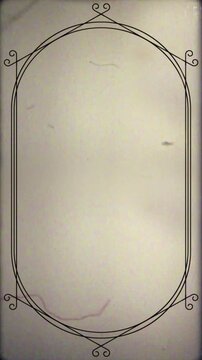 Vertical 9:16 vintage silent film frame overlay featuring a double-line black oval border with decorative corner flourishes, subtle vignette edges, flickering analog dust, hair and scratches