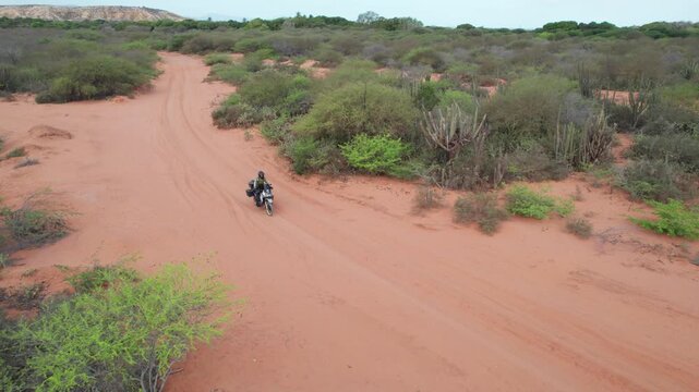 Aerial view of a motorcyclist on a dirt road in Araya, Venezuela.