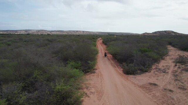 Aerial view of a motorcyclist on a dirt road in Araya, Venezuela.