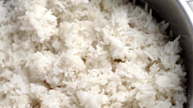 Close-up of freshly cooked fluffy basmati rice in a metal pot. Healthy home cooking and staple food concept