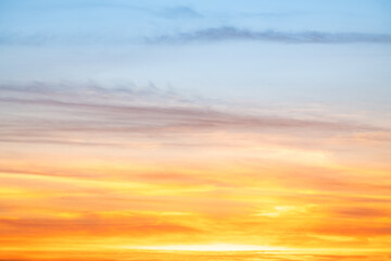 Fototapeta premium Sunset or sunrise sky with a vibrant gradient of orange, gold, and soft blue. Clear atmosphere with wispy clouds. Peaceful, natural light background. hope, freedom, new day and inspirational Concepts