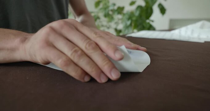 Close-up male hands fold sheet of paper making paper airplane. 4K 10-bit