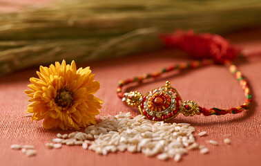 Obraz premium Raksha Bandhan, an Indian celebration marked by the beautiful Rakhi, rice grains, and flowers, is a traditional wrist band in India. It represents the love shared between sisters and brothers