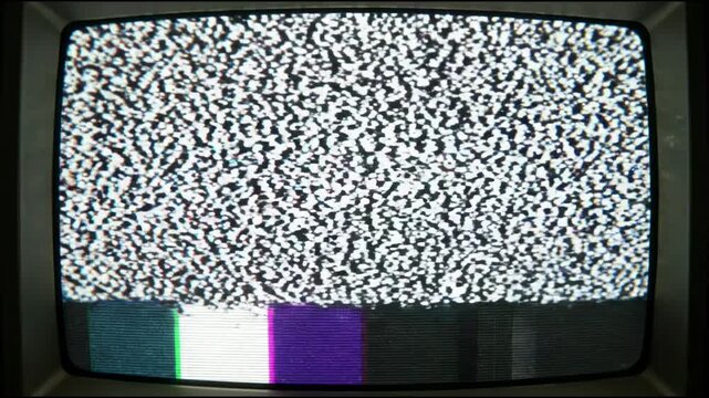 A television screen displays a test pattern featuring bright vertical stripes and color blocks. This is common in television broadcasting. The colors and design are eye-catching