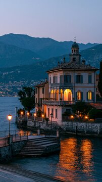 a picturesque coastal town situated on the shore of a lake. The main subject is a grand, multistory building with a classical architectural style, featuring ornate details and a dome on top.