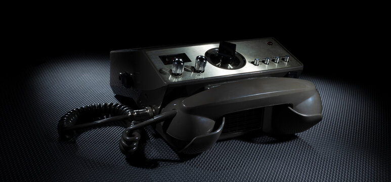 Two way radio with telephone handset on a dark background