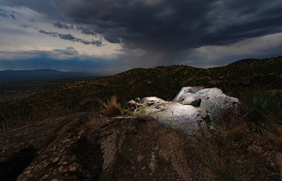 Rock outcropping lighted with flashes in Arizona's mountains with a storm behind