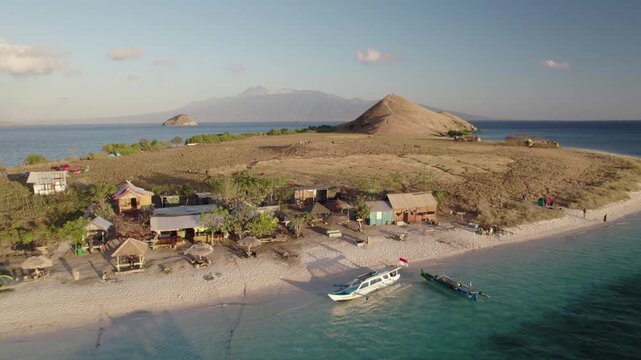 Aerial view of Kanawa Island with boats and tropical hills, Indonesia.