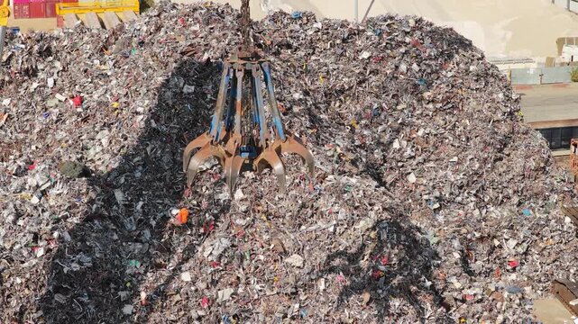 Crane Moving Scrap Metal at Recycling Center