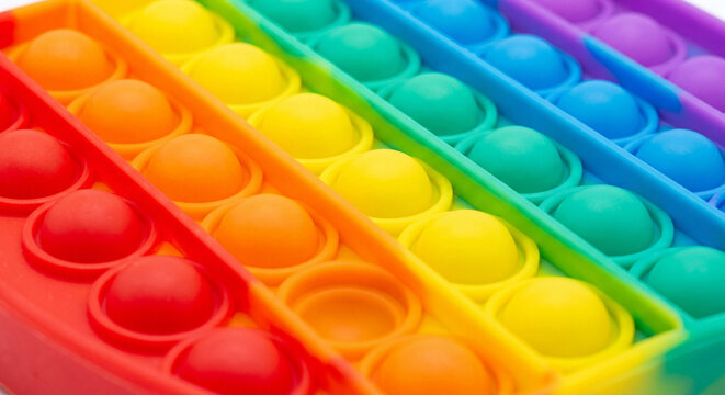 Rainbow silicone push bubble fidget toy macro photo of colorful sensory rows