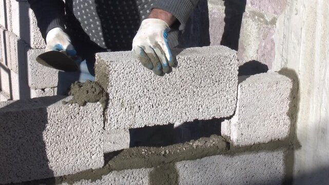 Construction Site Working Process with Workers Building a Brick Wall, Active Building Project Showing Masonry Work, Construction Materials and Skilled Labor During Residential or Commercial 