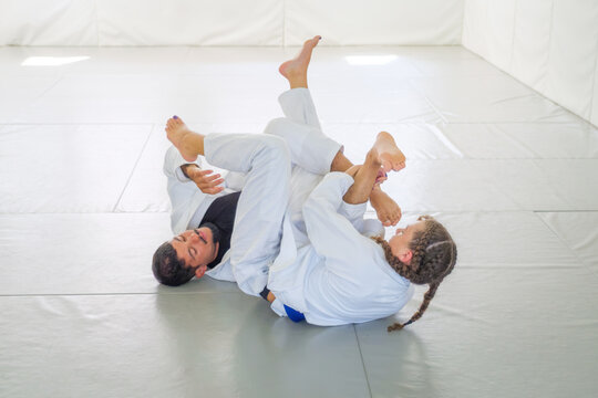 In Brazilian jiu jitsu, the bottom grappler swings a leg over the shoulder to threaten a submission while the top partner defends during ne waza