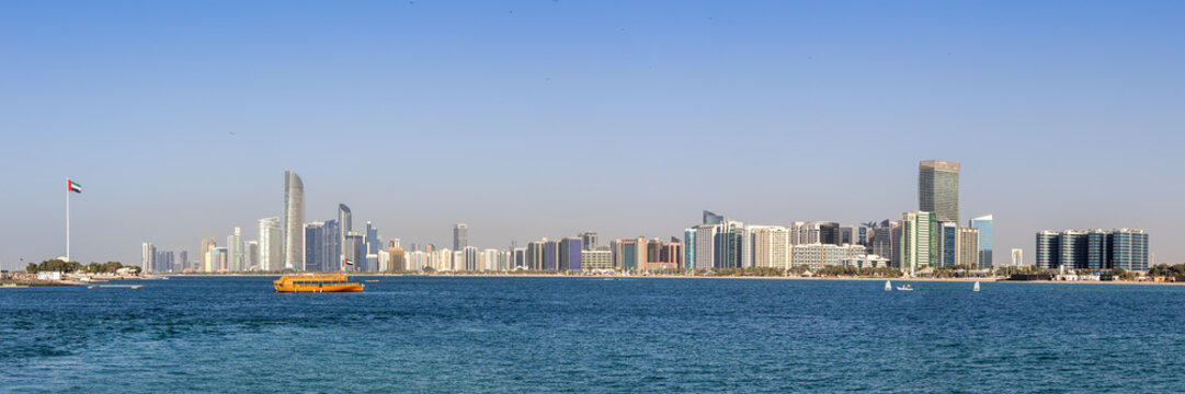 Abu Dhabi skyline with skyscrapers banner panoramic view and Dhow boat at sea in Abu Dhabi, United Arab Emirates