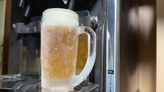 Draft Beer with Creamy Foam in a Frosted Mug: Beer Server Topping the Head, Then a Hand Lifts the Glass at a Japanese Izakaya