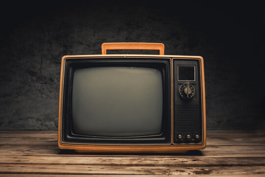 Retro yellow old TV blank screen on wooden on black background. Front view