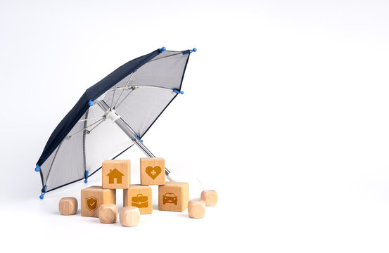 Umbrella shelters wooden blocks with icons for home, health, vehicle and business. Comprehensive insurance coverage, risk management, financial security and protection against multiple risks concept.