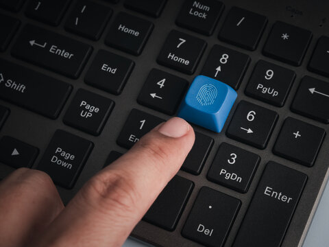 Close-up finger activates blue biometric fingerprint key on black  computer keyboard. Secure digital access, identity verification, passwordless authentication and enterprise cybersecurity concept.
