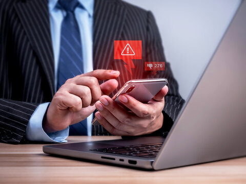Business professional checks a smartphone with warning and dislike notifications. Digital reputation risk, online backlash, negative feedback, brand damage and social media crisis management concept.