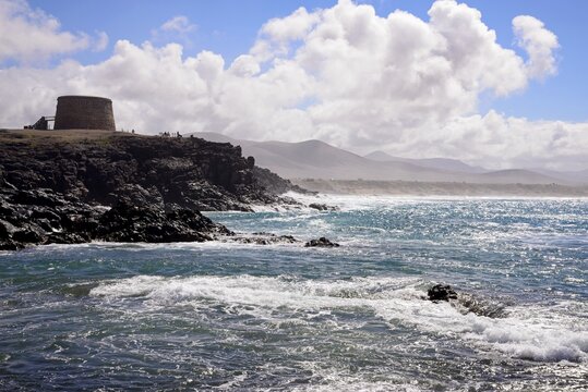 View of the rugged coastline with the castle to the right, El Cotillo, Fuerteventura, Canary Islands, Spain, Europe.