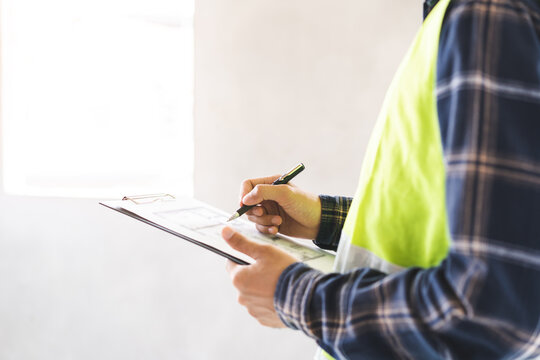 Building inspection asian contractor young man, male inspecting home, reconstructed construction, renovation or check defect, before finish handing it over to client, customer. Engineering worker.
