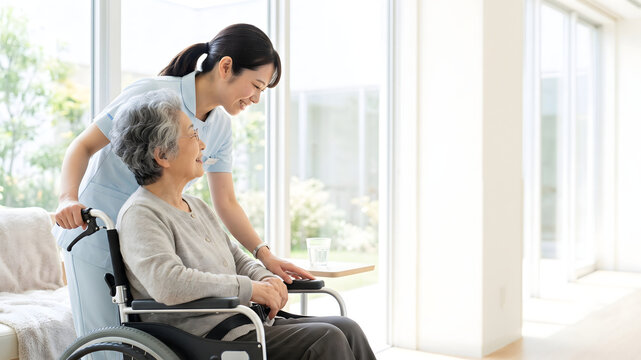 Caregiver assisting an elderly woman in a wheelchair at home