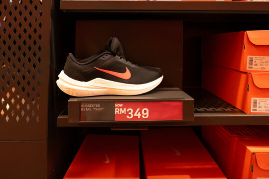 Athletic sneakers and shoppers beneath the Just Do It wall graphic at the Nike Factory Store on September 14, 2026 in Genting Highlands Premium Outlets, Pahang, Malaysia.   
