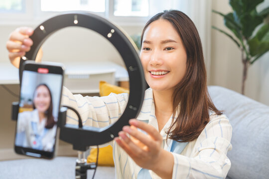 Influencer live internet, happy vlog asian young woman blogger set up using smart phone talking on video streaming podcast online on social media, digital marketing with mobile content creator concept