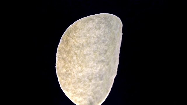 Formed Potato Crisp Showing Curved Geometric Shape on Black