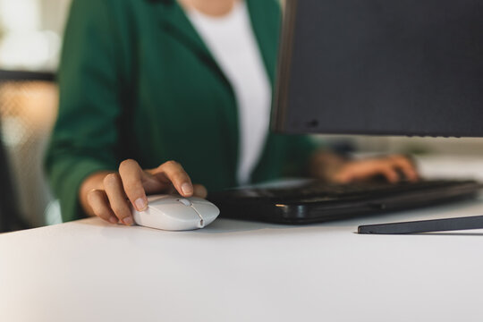 Woman hand using computer mouse at office workplace.