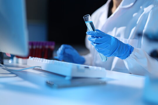Female scientist working on research in laboratory. Young woman scientist holding a test tube, conducting a science experiment in a modern laboratory for medical research.
