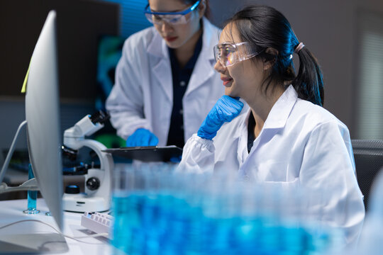 Woman scientists working on computer in science laboratory.
