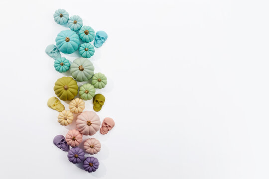 Pastel pumpkins and skulls creating rainbow halloween border