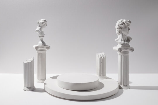 Classical white busts and columns on a minimal podium