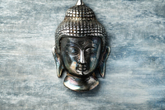 Buddha head on rustic wooden background. Soft focus. Top view. Copy space. 