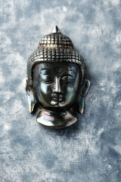 Buddha head on rustic wooden background. Soft focus. Top view. Copy space. 
