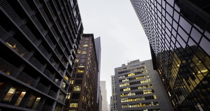Skyscraper facades mirror adjacent structures and streets, Reflective glossy surfaces on highrise facades mirror neighboring structures and empty street scene