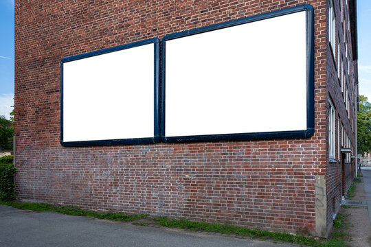 Blank advertising posters on a red brick wall in the city