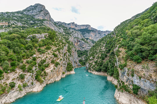 Tourists enjoying turquoise waters of the Verdon River in France, paddling pedal boats and kayaks on a sunny day