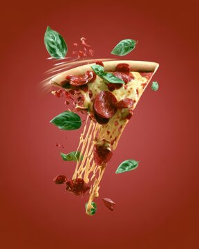 Floating slice of pepperoni pizza with basil leaves against red gradient background for food branding