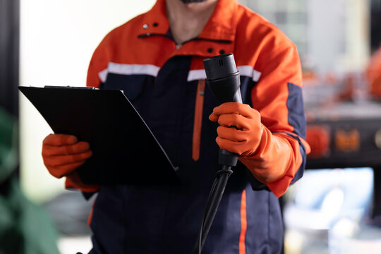 EV wall charger, Electric vehicle charging, Wall charger installation. Hands of technician install, checking, insert EV charging cable plug into station socket home EV charging station