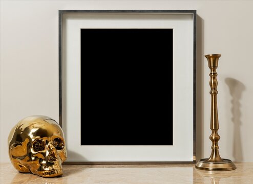Golden skull beside empty frame and brass candlestick