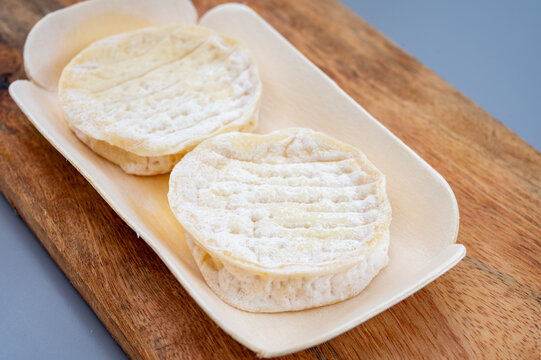 Rocamadour protected designation goat cheese from Occitanie region, France. Artisanal small-format soft cheese with creamy pale interior and natural rustic rind.